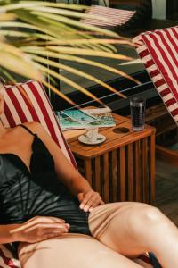 a woman sitting in a chair next to a table at Le Riviera - Hôtel Restaurant & Spa - Ex Golden Tulip Aix les bains in Aix-les-Bains