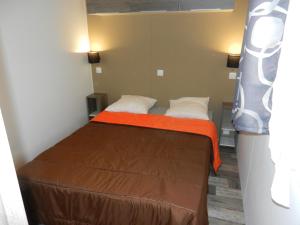 ヴィムルーにあるEté indien-hôtellerie de plein airの小さなベッドルーム(オレンジ色の毛布付きのベッド付)