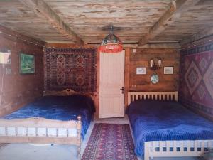 two beds in a room with wooden walls at Getaway in Chʼkhakoura