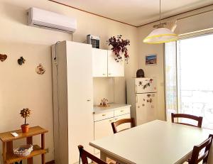 a kitchen with a table and a white refrigerator at Crateri e coralli in Mascali