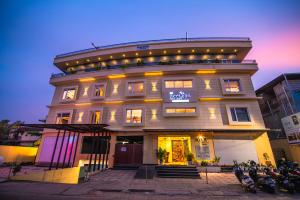 a large building with people sitting in front of it at Neelagiri Heritage Hotel - Near Calicut Railway Station in Kozhikode