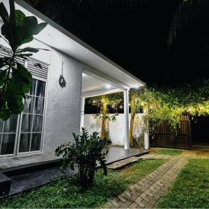 a white house with a porch at night at Villa Akeinya in Matara