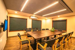 a conference room with a wooden table and chairs at Neelagiri Heritage Hotel - Near Calicut Railway Station in Kozhikode