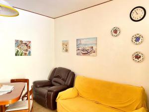 a living room with a couch and clocks on the wall at Crateri e coralli in Mascali