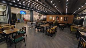 a restaurant with tables and chairs and a tv in the middle at FAVORİTE Hotel in Söğütlü