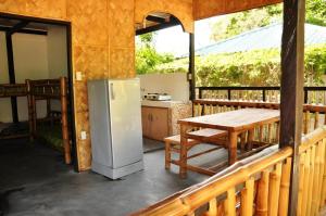 a patio with a refrigerator and a table on a porch at Paseo Verde Beach Resort in Laiya