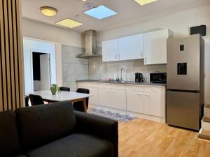 a kitchen with a table and a refrigerator at Padborg Inn - Simple Rooms & Modern Apartments in Padborg