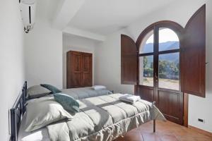 a bedroom with a large bed and a window at Fattoria San Pio in Naso
