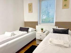 a bedroom with two beds and a window at Padborg Inn - Simple Rooms & Modern Apartments in Padborg