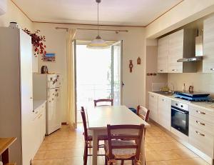 a kitchen with a table and chairs in a room at Crateri e coralli in Mascali +19 photos