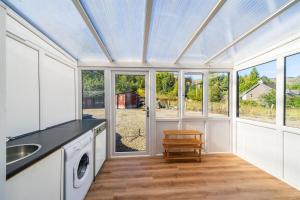 a kitchen with white cabinets and a sink and windows at Meadowview in Lochearnhead +4 photos