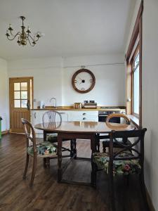 a dining room with a table and a clock on the wall at Meadowview in Lochearnhead