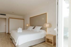 a bedroom with a large white bed with two pillows at R2 Buganvilla Hotel & Spa in Morro del Jable