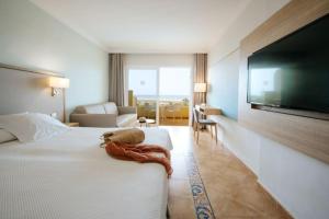 a hotel room with a bed and a flat screen tv at R2 Buganvilla Hotel & Spa in Morro del Jable