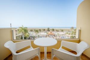 a table and chairs with a view of the beach at R2 Buganvilla Hotel & Spa in Morro del Jable
