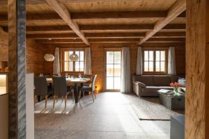 a dining room with a table and a couch at Chalet Selun - Luxury & Bergblick in Wildhaus