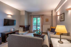 a living room with two couches and a television at Harmony Hotel Apartments in Selianitika