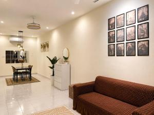 a living room with a couch and a table at iHomie Suites - 4Bedroom Homestay Kulim in Kulim