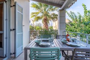 a wooden table and chairs on a balcony with a table at Harmony Hotel Apartments in Selianitika