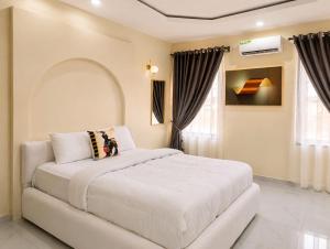 a bedroom with a large white bed in a room at Little Afrika in Port Harcourt