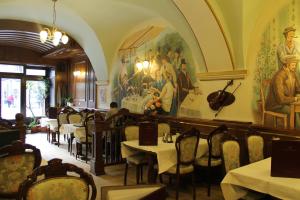 a restaurant with tables and chairs and a painting on the wall at Pension Casa Frieda in Sibiu