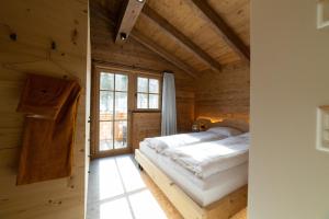 a bedroom with a bed in a wooden house at Chalet Selun - Luxury & Bergblick in Wildhaus