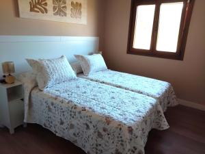 a bedroom with two beds and a window at Apartamentos Turísticos El Collau in La Robellada de Onis