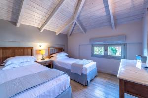 two beds in a bedroom with wooden ceilings at Harmony Hotel Apartments in Selianitika +79 photos