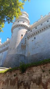 a large white castle with a tree in front of it at Au Nid Douillet in Gilocourt