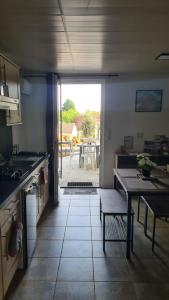a kitchen with a table and a view of a patio at La lisière tarnaise in Labastide-de-Lévis +13 photos