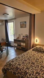 a bedroom with a bed and a table and a window at La lisière tarnaise in Labastide-de-Lévis