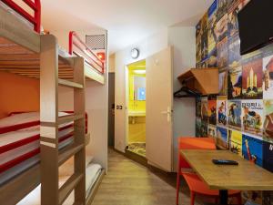 a small room with bunk beds and a dining table at hotelF1 Nemours in Nemours