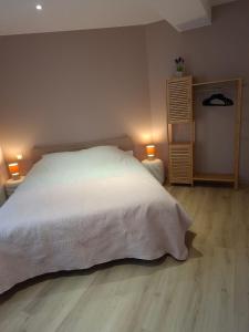 a bedroom with a white bed and a wooden floor at F2 neuf grande terrasse chemin de Stevenson proche Le Puy in Coubon