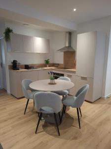 a kitchen with a table and chairs in a room at F2 neuf grande terrasse chemin de Stevenson proche Le Puy in Coubon
