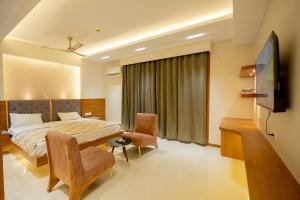 a hotel room with a bed and a tv at Hotel Om Sai Villa Gomti Nagar, Lucknow in Lucknow +18 photos