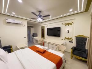 a bedroom with a bed and a flat screen tv at Hotel Om Sai Villa Gomti Nagar, Lucknow in Lucknow