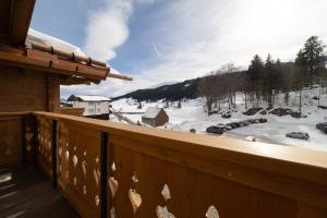 a balcony with a view of a snow covered yard at Chalet Selun - Luxury & Bergblick in Wildhaus