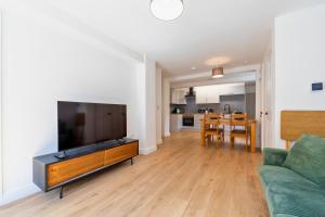 a living room with a couch and a flat screen tv at New 3 Bedroom Apartment Next to Station in Chepstow