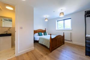 a bedroom with a bed and a kitchen at New 3 Bedroom Apartment Next to Station in Chepstow