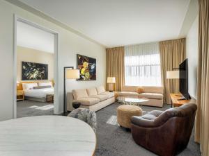 a living room with a couch and a table in a room at 21c Museum Hotel Bentonville - MGallery in Bentonville +79 photos