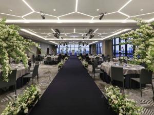 a banquet hall with tables and chairs and flowers at Mercure Ambassador Ulsan in Ulsan