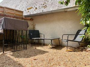 a group of chairs and a table next to a building at Détente aux beaumonts in Chouzy-sur-Cisse