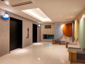 a lobby with a waiting room with chairs and a fireplace at ibis Budget Osaka Umeda in Osaka