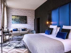 a hotel room with a large bed and a couch at Mercure Figeac Viguier du Roy in Figeac +101 photos