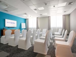 a conference room with white chairs and a screen at Novotel Bur Dubai - Healthcare City in Dubai +62 photos
