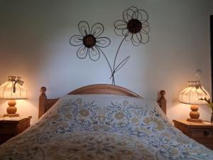 a bedroom with a bed with a flower on the wall at Pacsirta Porta in Nemesnép