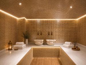 ein Badezimmer mit zwei Waschbecken in einer gefliesten Wand in der Unterkunft Seven Beautiess Hotel in Baku
