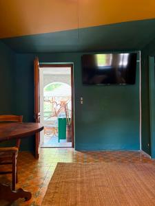 ein Zimmer mit einer grünen Wand und einem Flachbildfernseher in der Unterkunft CaDMARTA in Vico Canavese