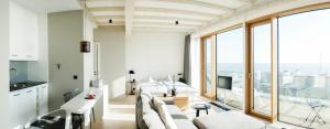a living room with white furniture and large windows at Inselloft Norderney in Norderney