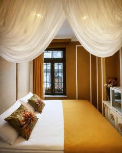 ein Schlafzimmer mit einem Bett mit Vorhängen und einem Fenster in der Unterkunft Seven Beautiess Hotel in Baku